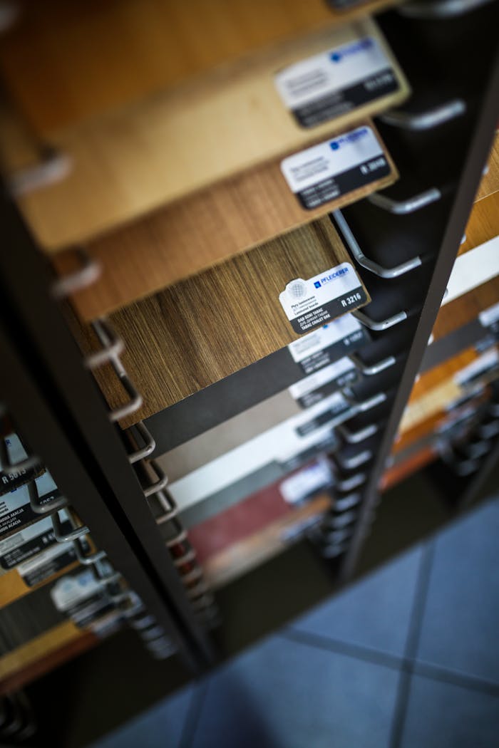 Home Close-up of various laminated wood veneer samples in a showroom display rack.